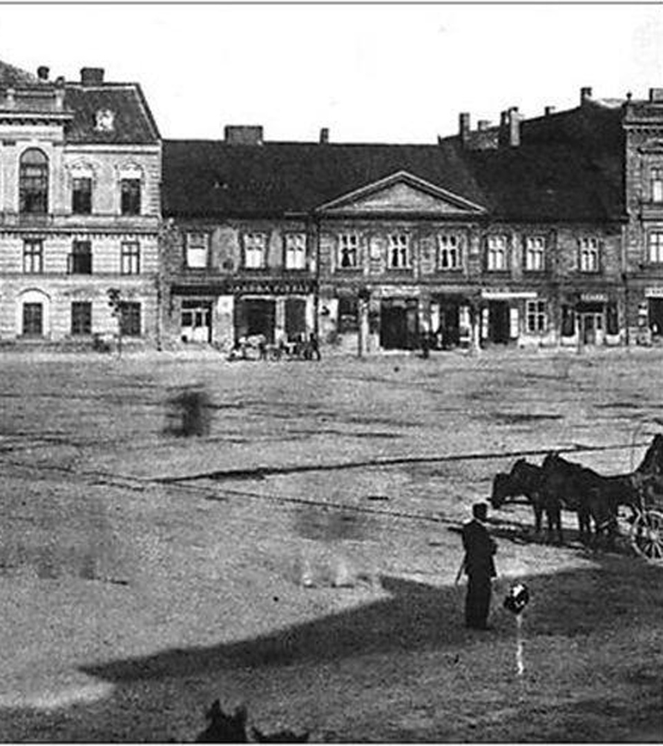 A black-and-white photo of Krakow’s Rynek Podgórski 2, featuring historic buildings and a carriage, reflects early 20th-century Judaica heritage—echoing stories preserved in the MEZUZAH KRAKOW Rynek Podgórski 2 (Copy) collection.