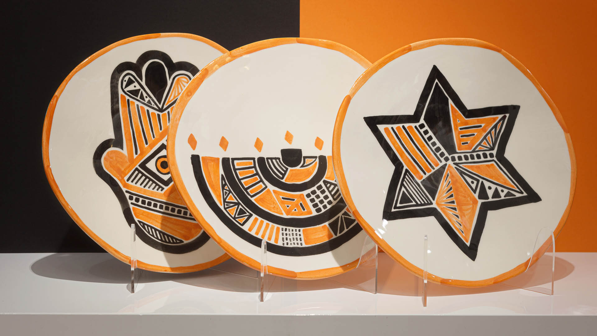 A set of hand-painted Jewish plates. Featuring the Star of David, Hamsa, and Menorah, these plates are hand-painted by Helena Czernek.