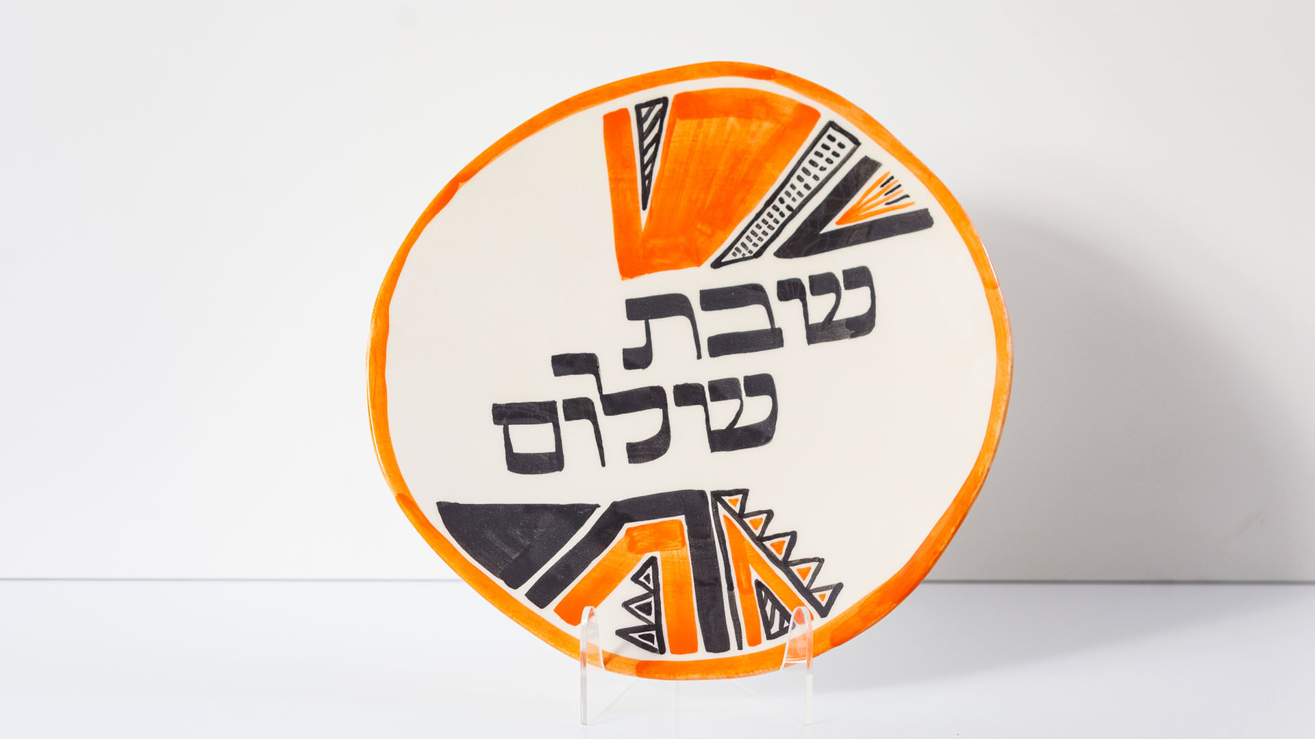 Shabbat Shalom Jewish plate. The ceramic plate was treated as a painting. The Shabbat Shalom plate was hand-painted by Helena Czernek co-designer MI POLIN, who, together with Aleksander Prugar, developed the unique painting patterns. The plates painting are inspired by the Cubist style and Polish graphic design of the 1960s and 1970s. Made at MI POLIN and entirely manufactured in Poland.