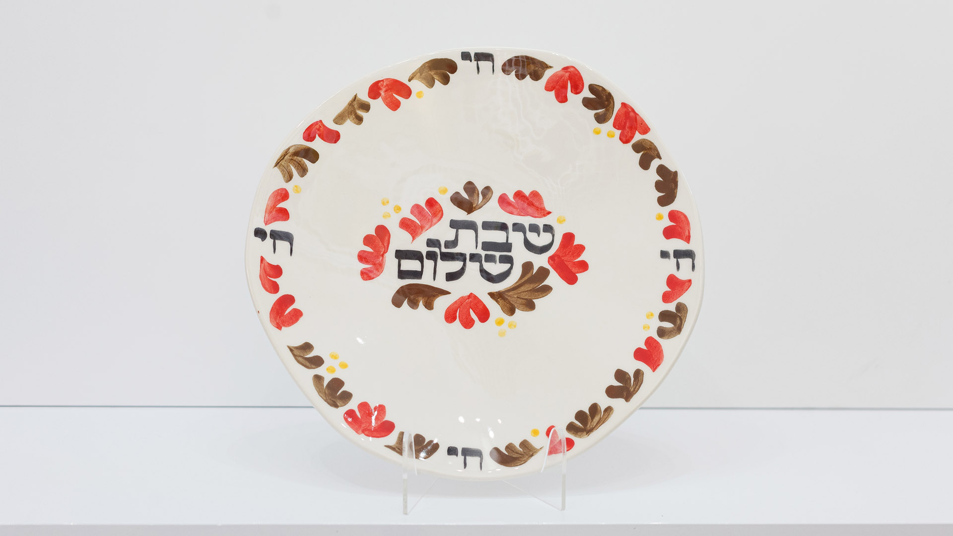 Shabbat Shalom Jewish plate. The ceramic plate was treated as a painting. The Shabbat Shalom plate was hand-painted by Helena Czernek co-designer MI POLIN, who, together with Aleksander Prugar, developed the unique painting patterns. The plates painting are inspired by Polish graphic design of the 1960s and 1970s. This refers to the pottery factories of Włocławek and Tułowice. Made at MI POLIN and entirely manufactured in Poland.