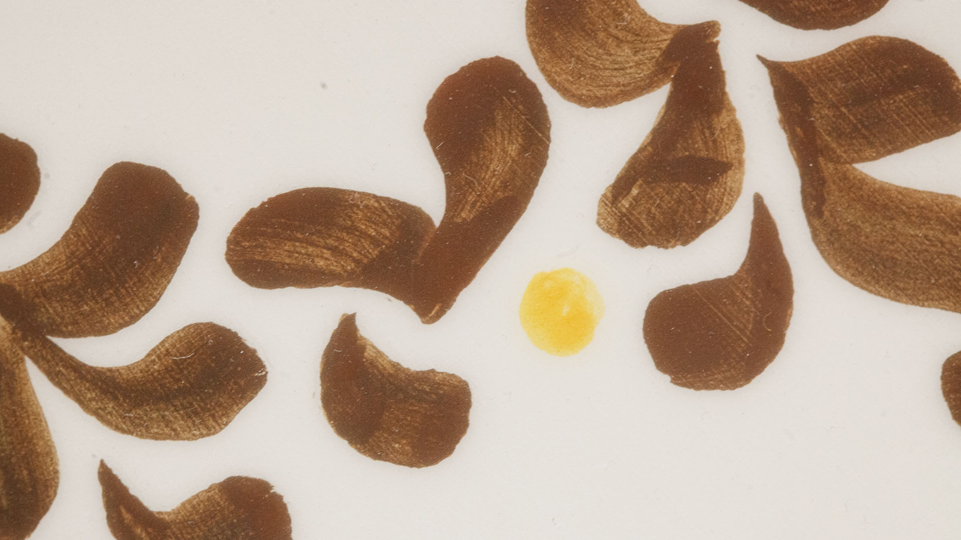 A close-up of a hand-painted plate with a Star of David plate. Hand-painted Jewish Judaica. Brushstrokes and ceramic glaze are visible. Highly precise craftsmanship.