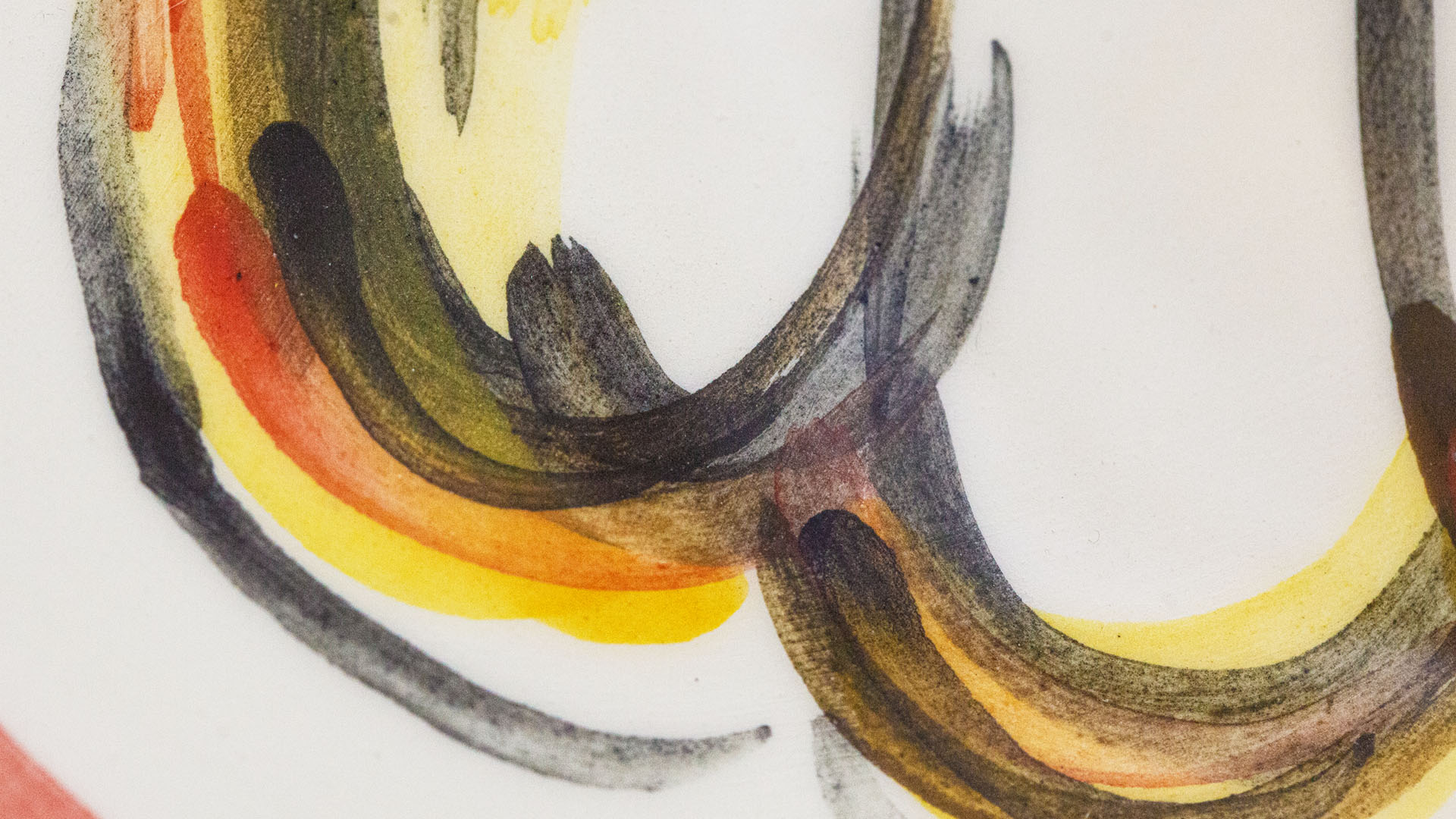 A close-up of a hand-painted plate with a Hamsa plate. Hand-painted Jewish Judaica. Brushstrokes and ceramic glaze are visible. Highly precise craftsmanship.