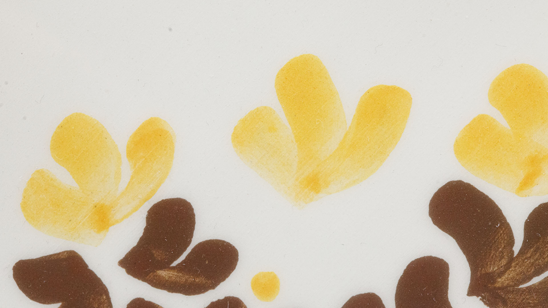 A close-up of a hand-painted plate with a Menorah plate. Hand-painted Jewish Judaica. Brushstrokes and ceramic glaze are visible. Highly precise craftsmanship.