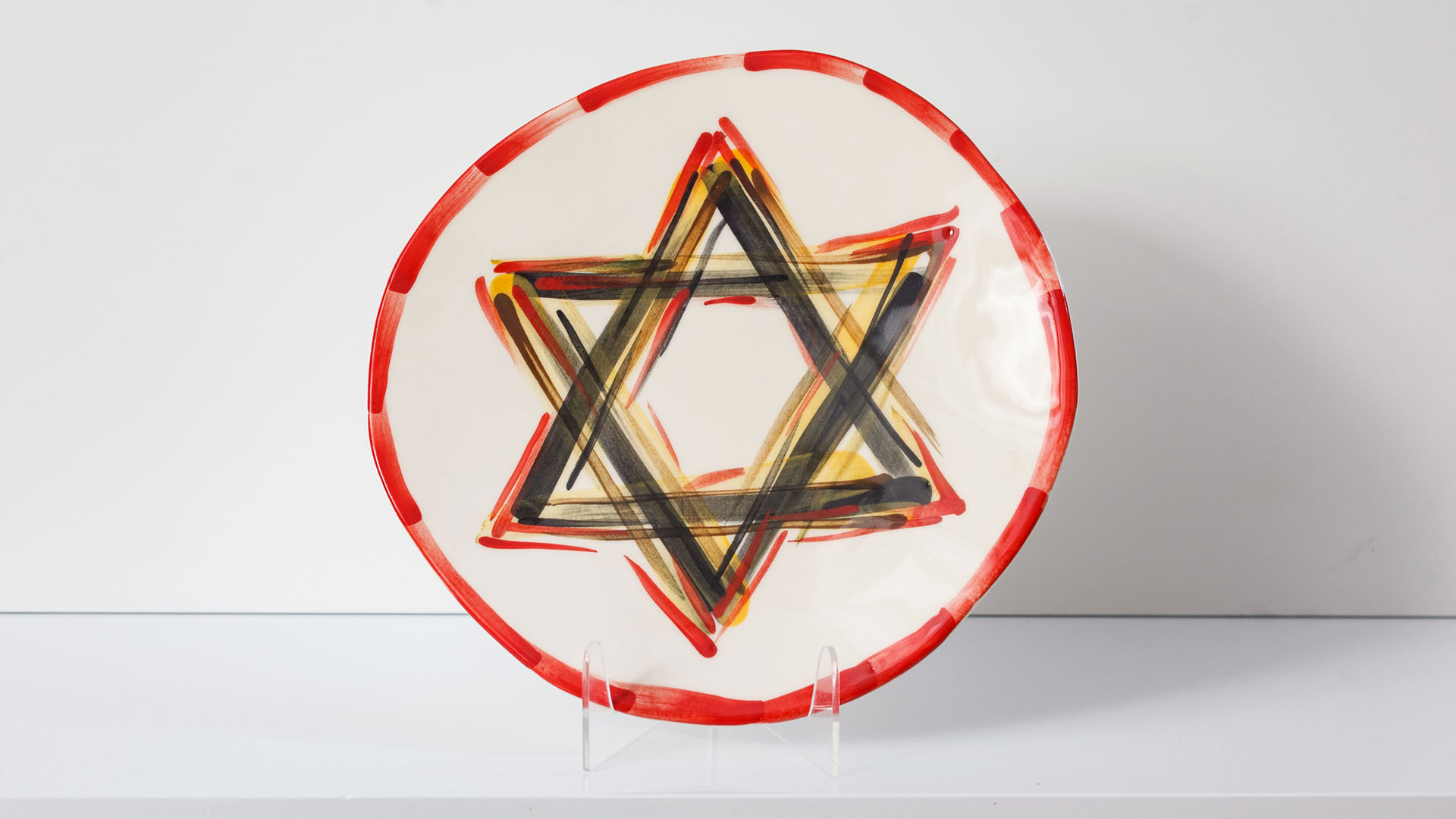 Star of David plate. The ceramic plate was treated as a painting. Star of David plate was hand-painted by Helena Czernek co-designer MI POLIN, who, together with Aleksander Prugar, developed the unique painting patterns. The plates painting are inspired by Polish graphic design of the 1960s and 1970s. This refers to the pottery factories of Włocławek and Tułowice. Made at MI POLIN and entirely manufactured in Poland.