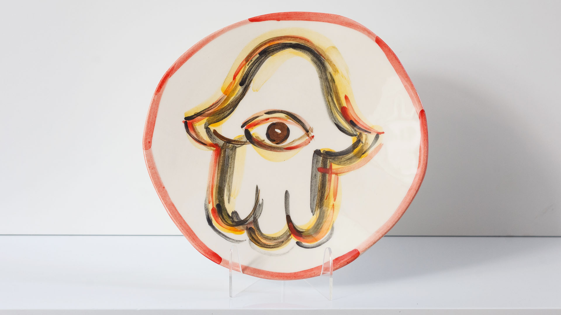 Hand painted Judaica. Seder plate with Hamsa decoration which consists of decorative elements in the form of lines in dark orange, brown and black stripes. Hand-painted by Helena Czernek MI POLIN, together with Aleksander Prugar. A perfect gift for a Bar Mitzvah, Bat Mitzvah, birthday, or as a decoration in a modern Jewish home.